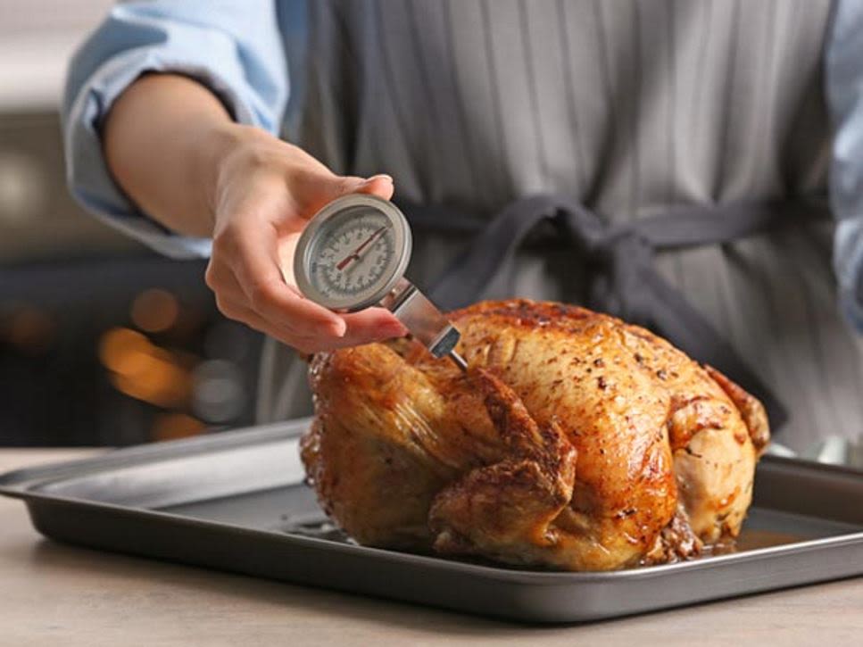 Thermometer probe placed in a roast chicken.